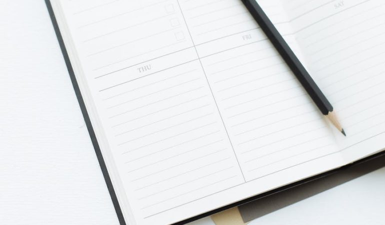 opened diary with pencil placed on desk